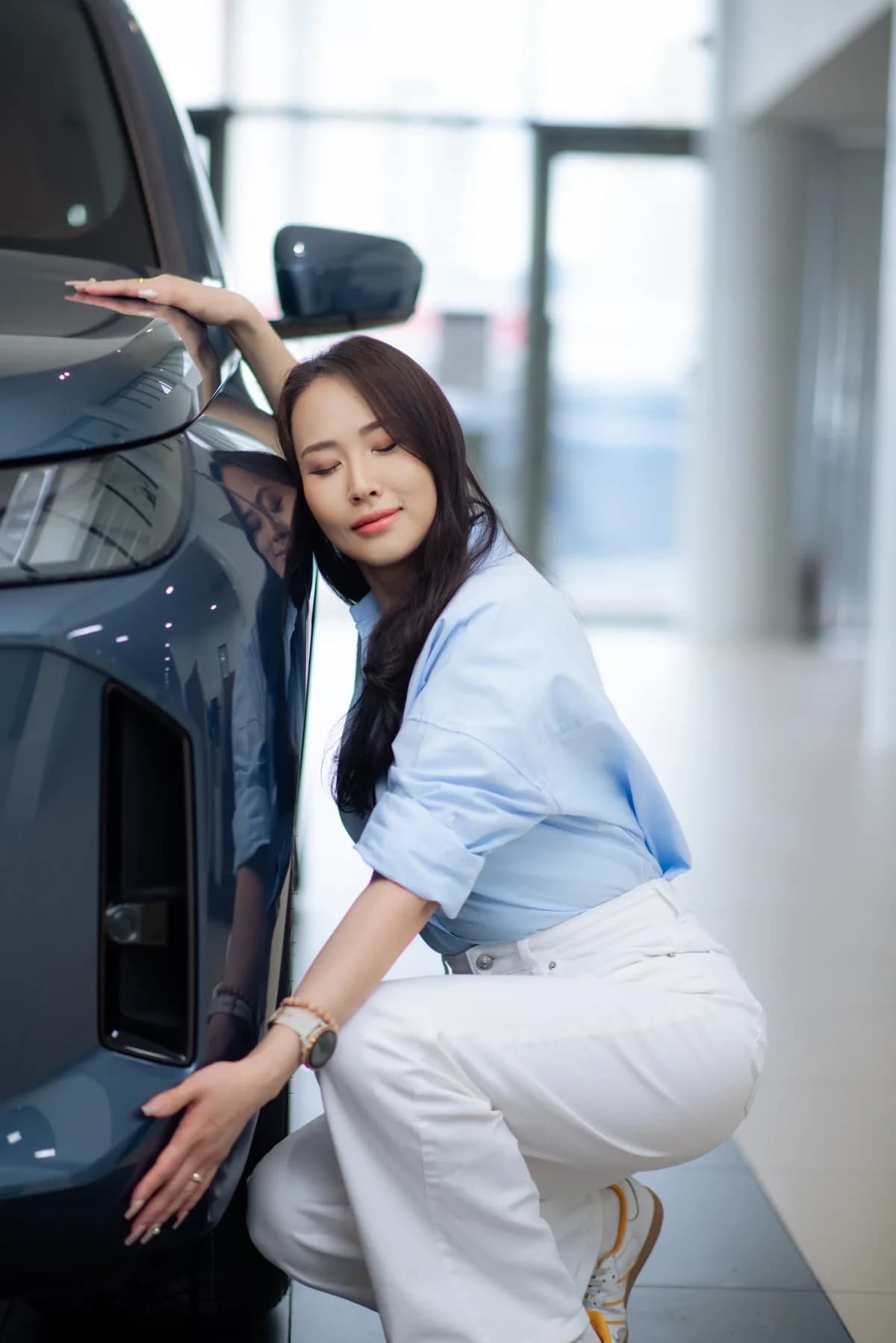 Vehicle owner leaning against the side of her car